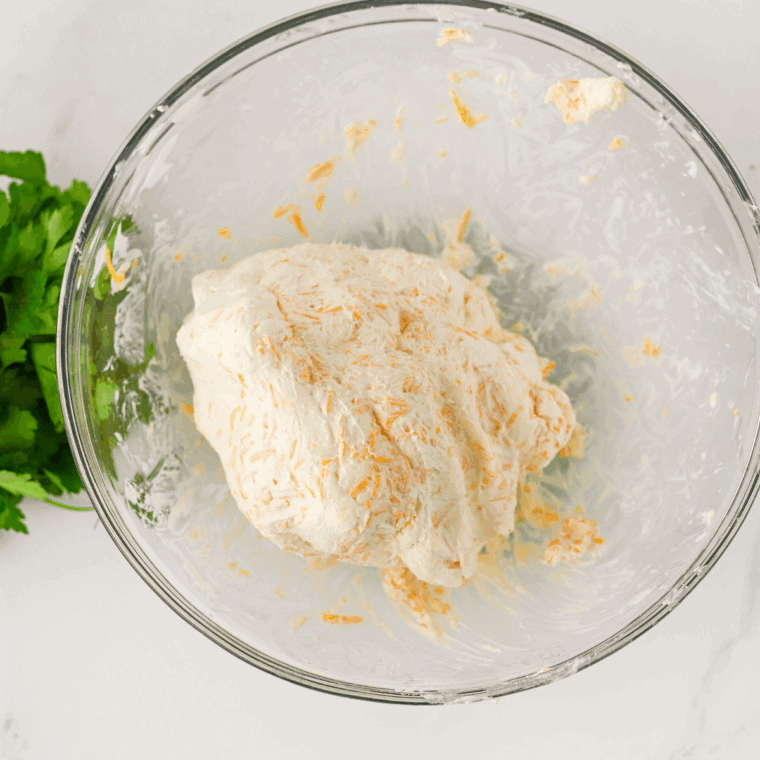 Cream cheese, sour cream, cheddar, and seasonings mixed in bowl