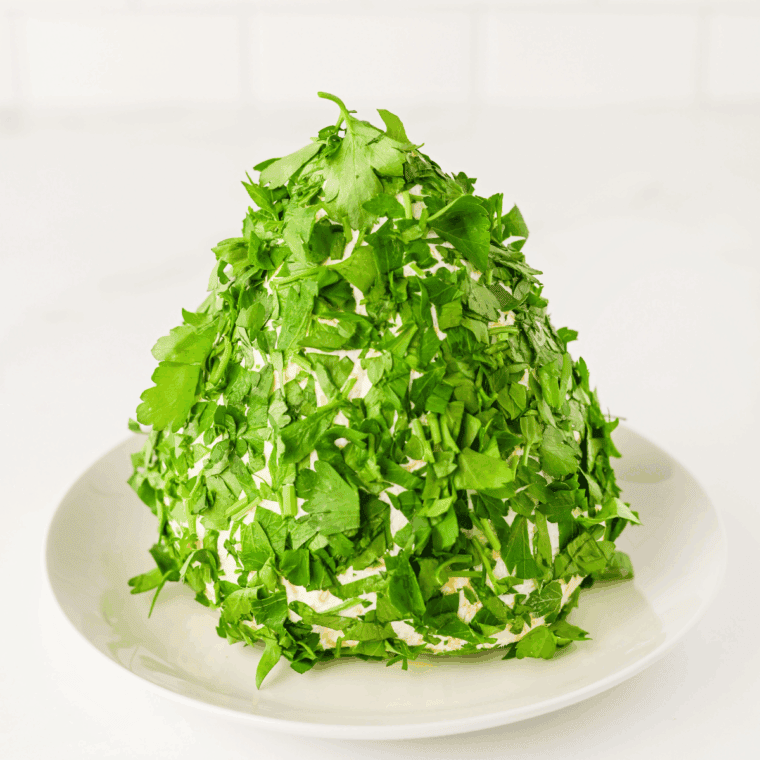 Parsley coating being pressed onto cheese ball