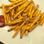 air fryer fries tossed with dill pickle Grinch salt seasoning in a shaker bag