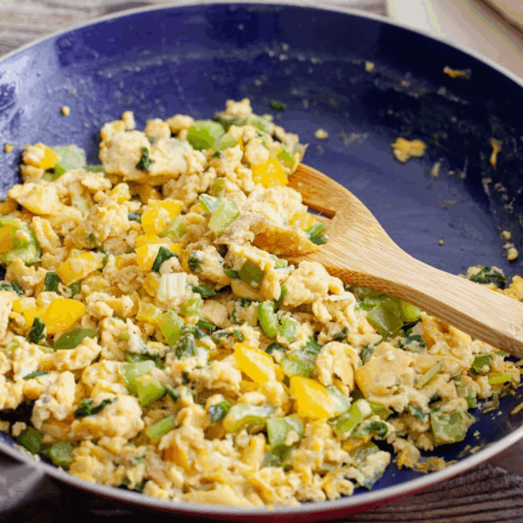 Sautéing green onions and bell peppers in olive oil in a nonstick skillet.