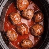 Crock pot filled with tender, cooked frozen meatballs in savory sauce