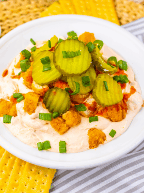 Bowl of Easy Nashville Hot Chicken Dip topped with seasoning and served with chips.