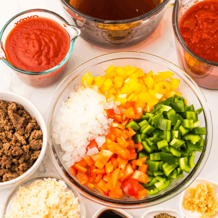Ingredients needed for Easy Slow Cooker Stuffed Pepper Soup on kitchen table.