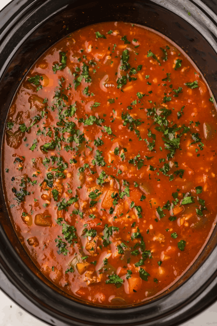 Ingredients for Stuffed Pepper Soup including ground beef, diced bell peppers, rice, and tomato sauce.