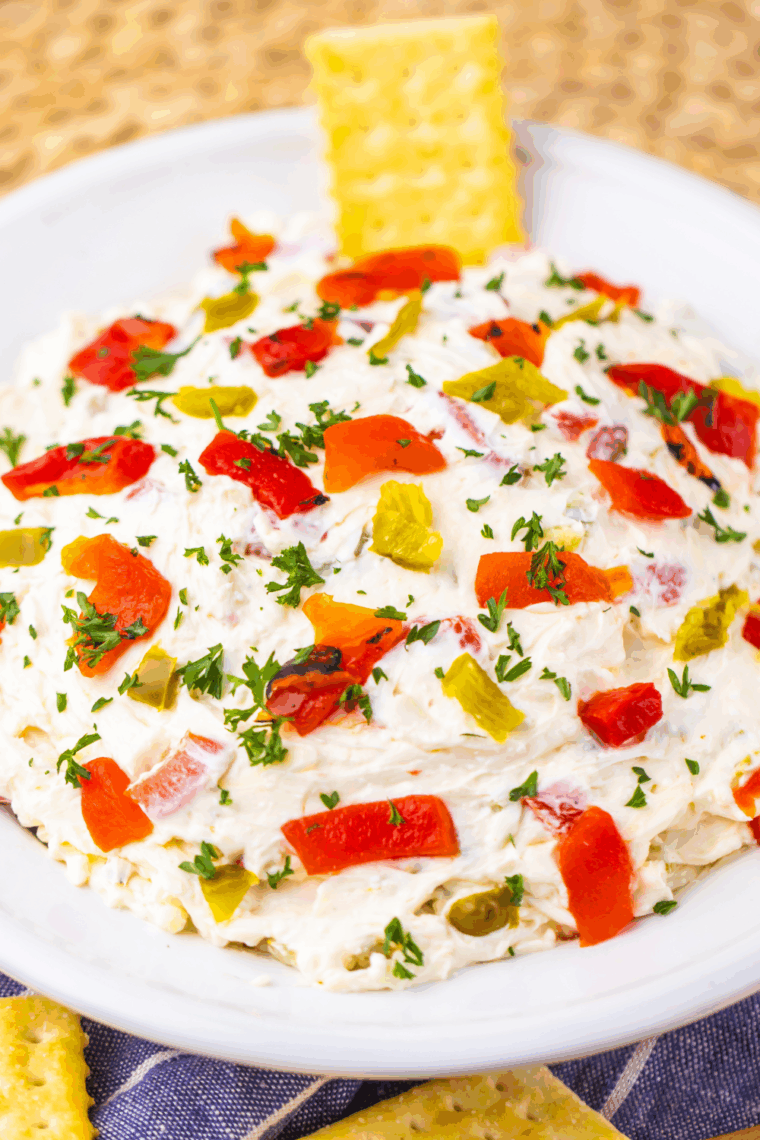 Easy Texas Christmas Dip in a festive bowl with melted cheese, roasted red peppers, and jalapeños, surrounded by tortilla chips.