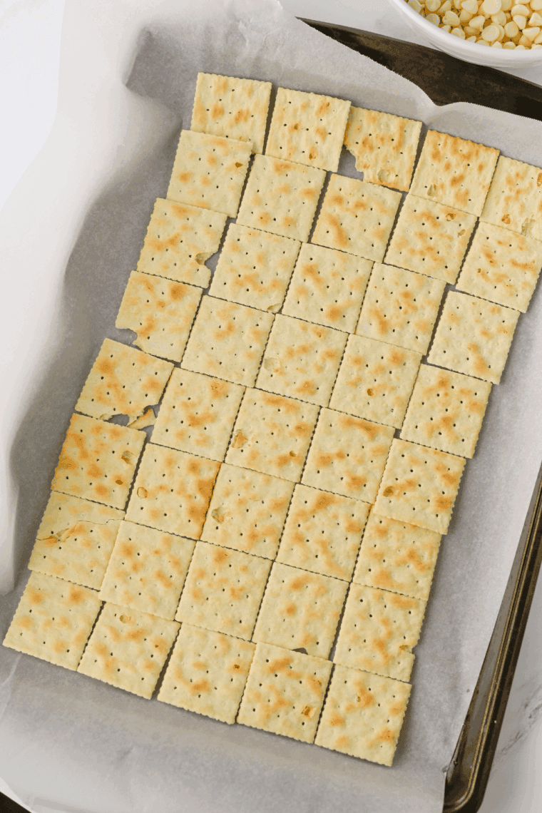 Saltine crackers arranged in single layer on baking sheet