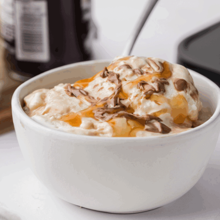 Bowl of Ninja Creami Ben and Jerry’s Vanilla Caramel Fudge ice cream with caramel swirls and chocolate chunks