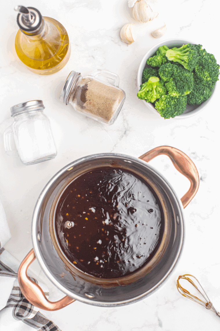 Whisking miso paste, soy sauce, honey, garlic, and ginger in a saucepan.