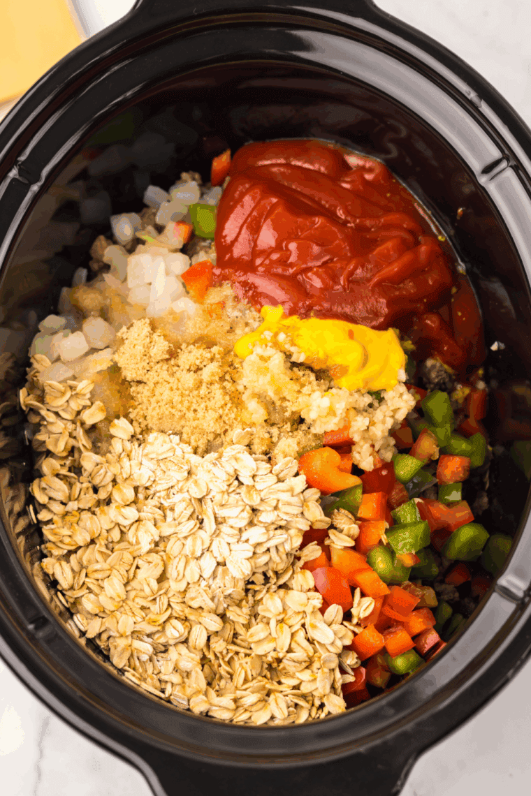 Ground beef, diced onions, garlic, and bell peppers added to slow cooker