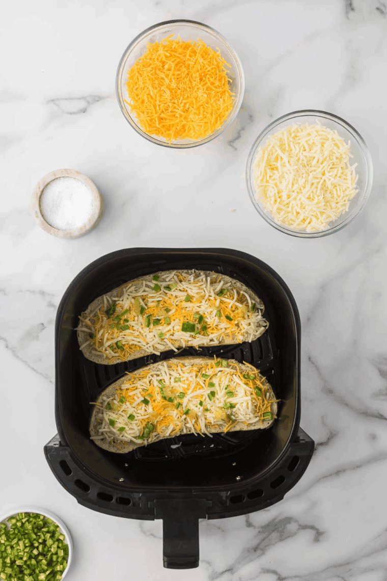 Cheese-topped bread slices cooking in the air fryer until golden and bubbly