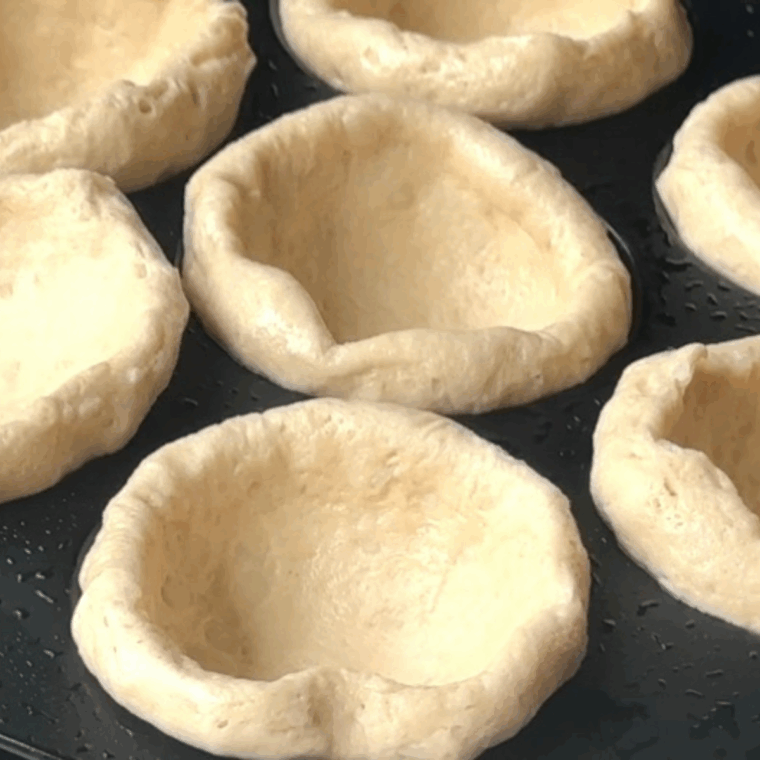 Refrigerated biscuit dough pressed into egg bite mold and sprayed air fryer basket