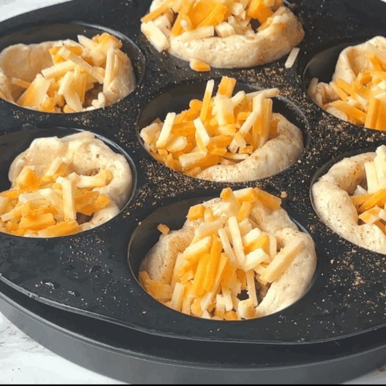 Add shredded cheese on top of the taco bites.