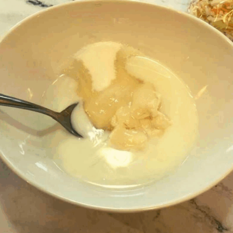 Creamy coleslaw dressing made with mayonnaise, sugar, apple cider vinegar, lemon juice, salt, and black pepper whisked together.