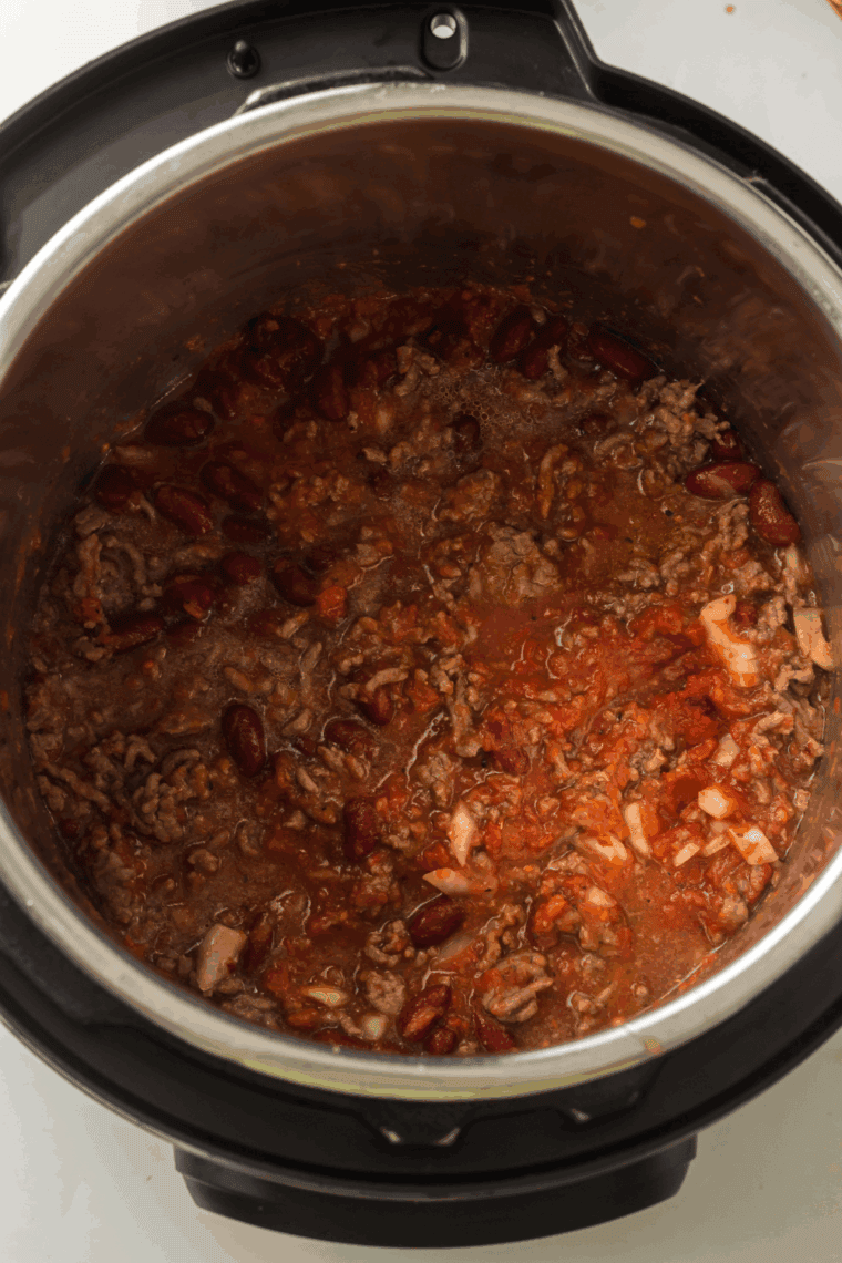 A close-up of an Instant Pot lid in the locked position with the steam valve set to the sealing move.
