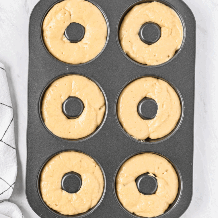 Placing donuts in sprayed air fryer basket and cooking until golden brown