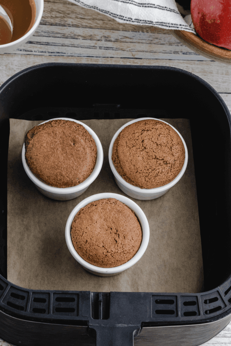 Easy air fryer salted caramel apple mug cake in a mug topped with caramel drizzle