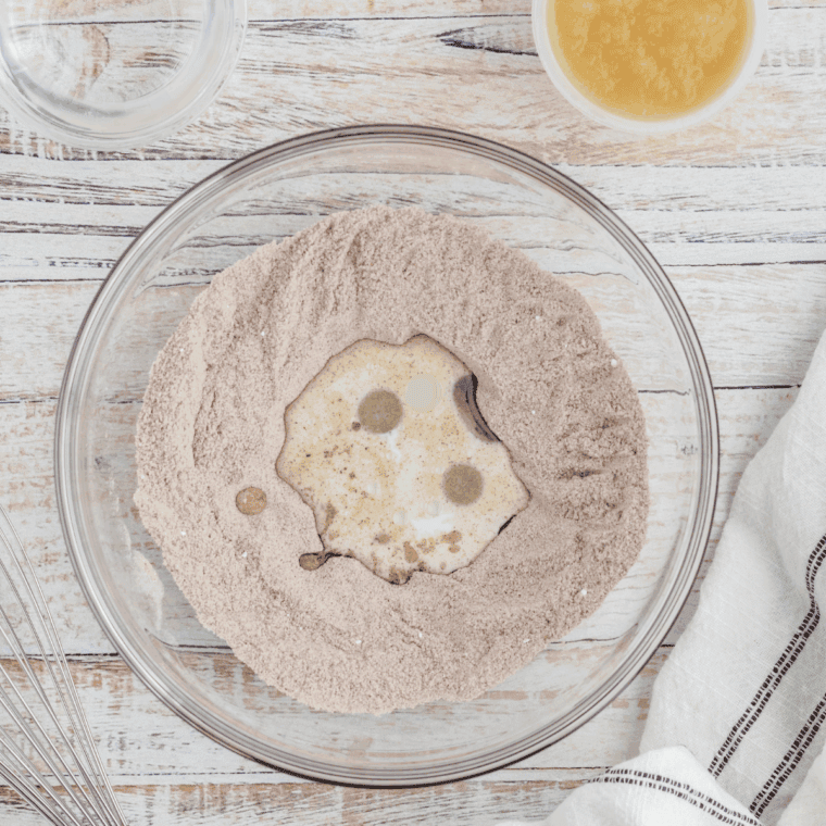 Small bowl with flour, apple pie spice, baking powder, sugar, and salt being whisked together