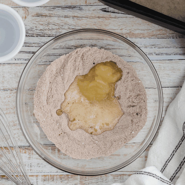 Mixing applesauce, milk, vegetable oil, and water into smooth mug cake batter