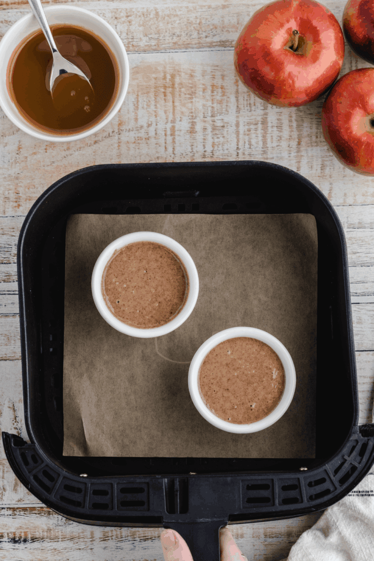 Mug filled with batter placed in air fryer basket ready to cook