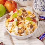 Bowl of Easy Candy Bar Apple Salad with chopped apples, candy bar pieces, and creamy dressing.