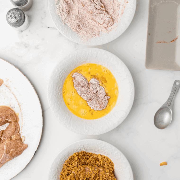 Coating chicken tenders in flour, egg wash, and breadcrumbs.