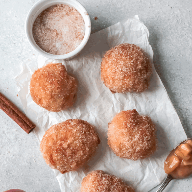 Freshly fried First Watch-style donuts coated with glaze or powdered sugar, golden and fluffy.