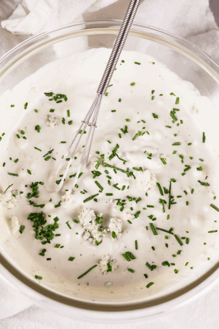 Stirring spices, chives, jalapeño brine, and chipotle into creamy sauce