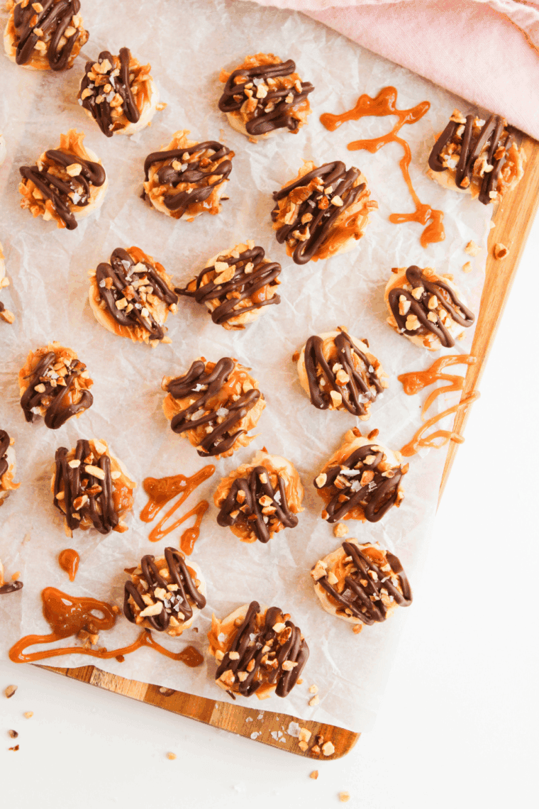 Easy Frozen Banana Snickers Bites on parchment paper.