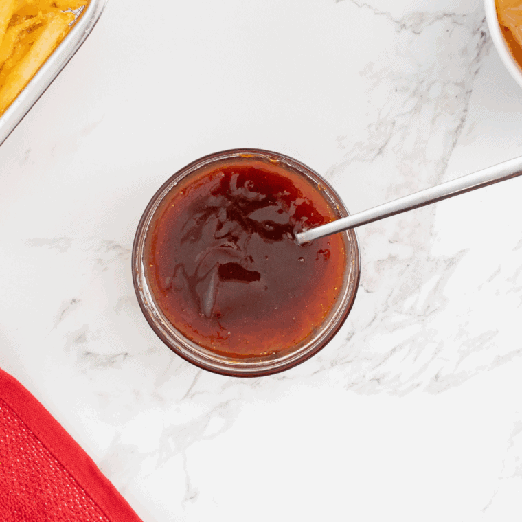 Easy hot honey BBQ sauce simmering in saucepan with rich glossy texture