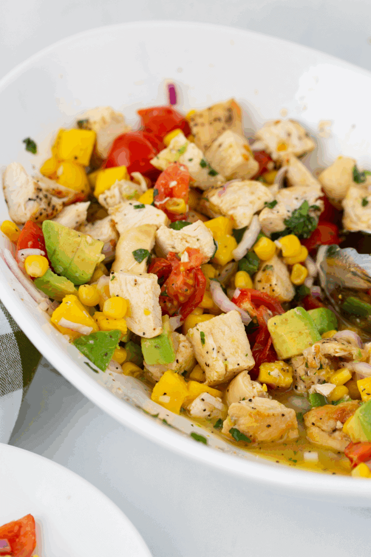 Smooth homemade mango salad dressing in a small bowl with fresh mango pieces