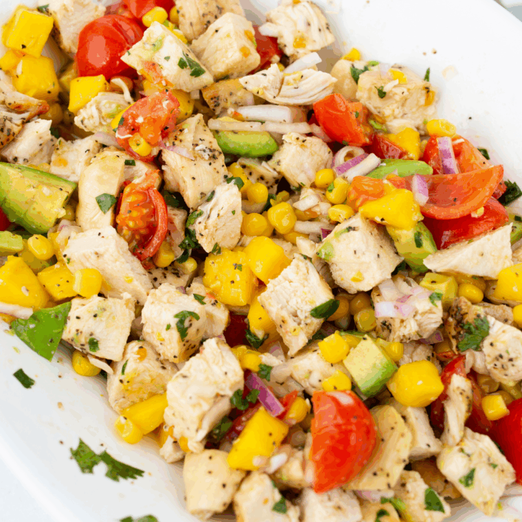 Fresh homemade mango salad dressing in a bowl with ripe mango pieces