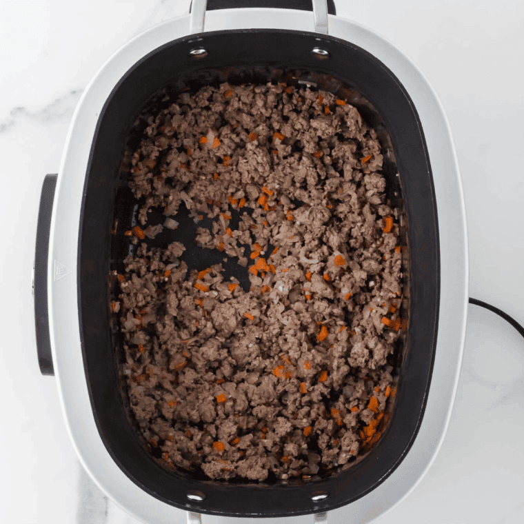 Browning ground beef and Italian sausage in skillet for bolognese sauce