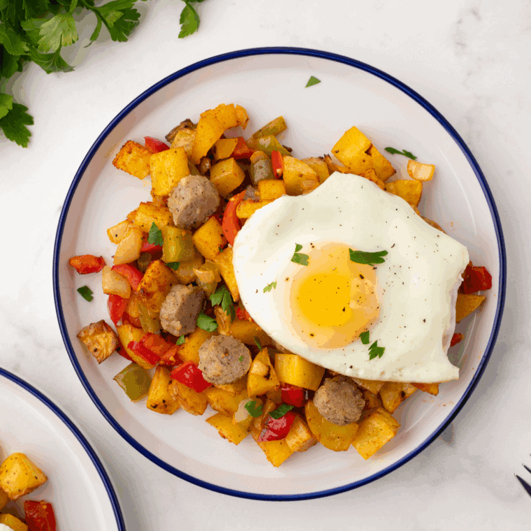 First Watch Copycat Market Hash with golden potatoes, saut&eacute;ed bell peppers, onions, mushrooms, chicken, fresh spinach, and melted cheddar cheese, served on a plate.