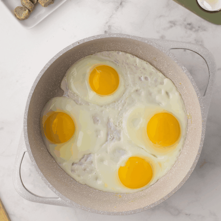 Cook sunny side eggs up in the frying pan.