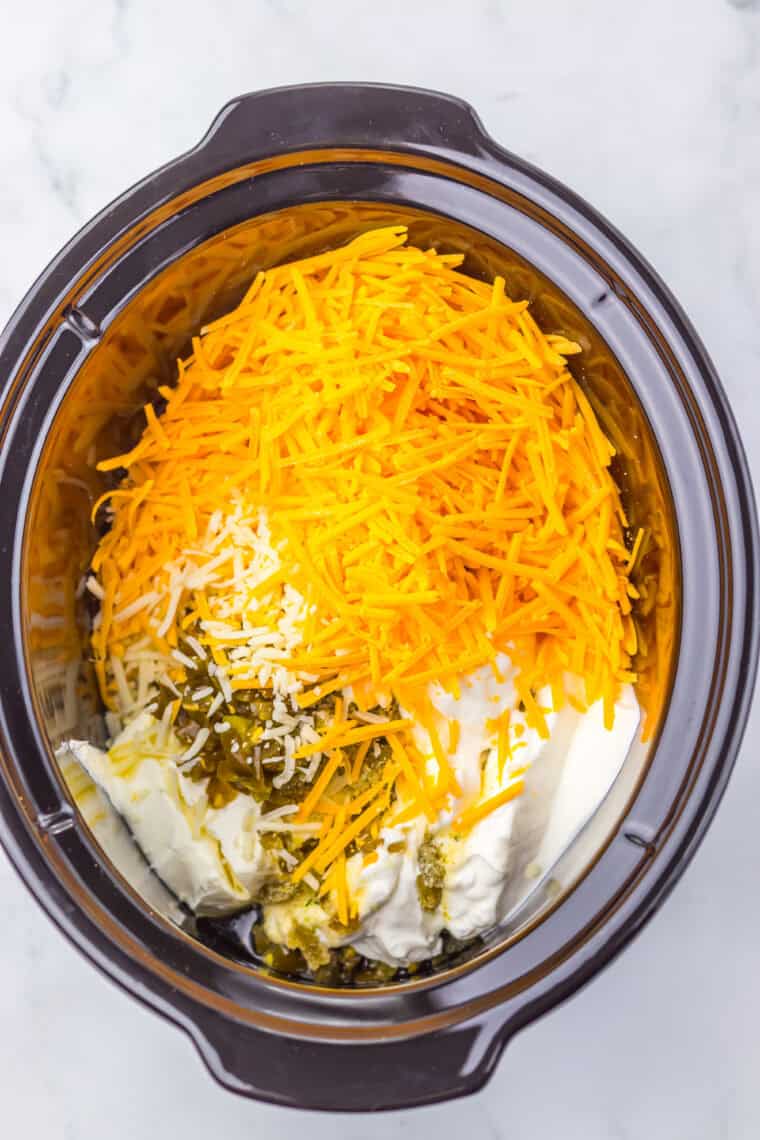 Slow cooker filled with cream cheese, sour cream, cheeses, and jalape&ntilde;os