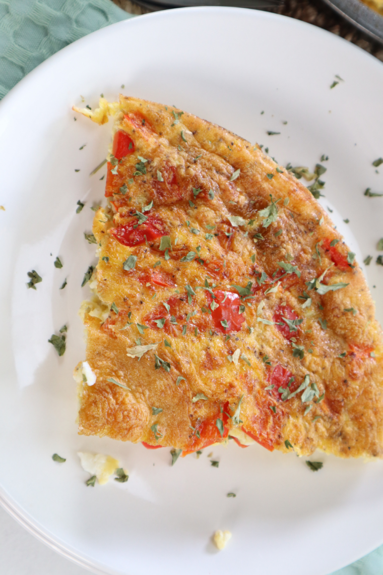 Air fryer egg white and roasted red pepper egg bites on a plate, golden and fluffy, garnished with chopped fresh chives