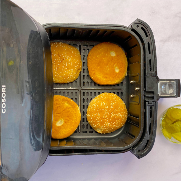 Soft sandwich buns toasting in the air fryer at 400&deg;F for 1&ndash;2 minutes until lightly golden.