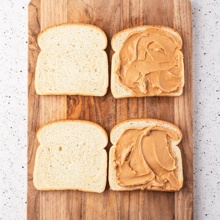 Slices of bread laid out on a surface, add your peanut butter.