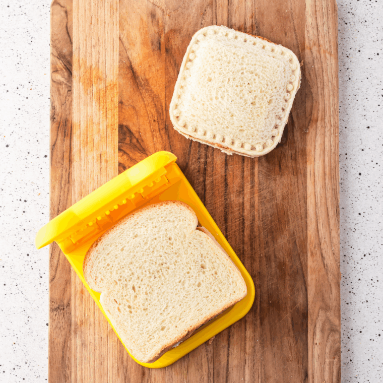 Pressing bread slices together and sealing edges with a cookie cutter.