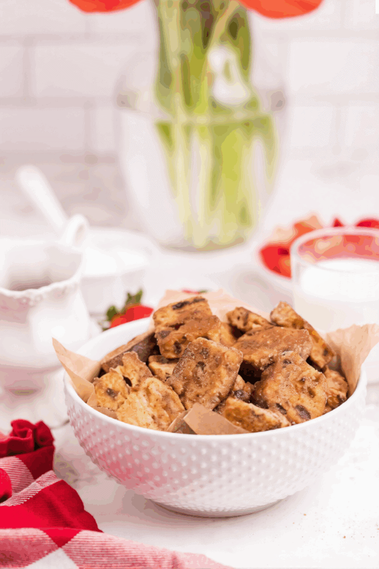 Golden air fryer French toast bites served with syrup on a plate