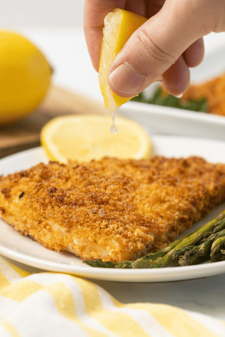 Golden panko crusted red snapper fillet cooked in air fryer, served with lemon and herbs