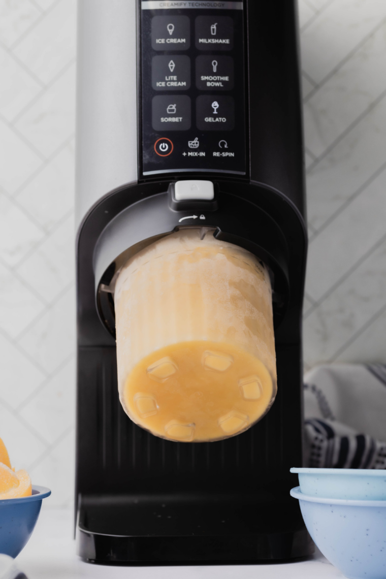 Placing frozen pint into Ninja Creami machine and selecting the Gelato setting to churn until creamy.