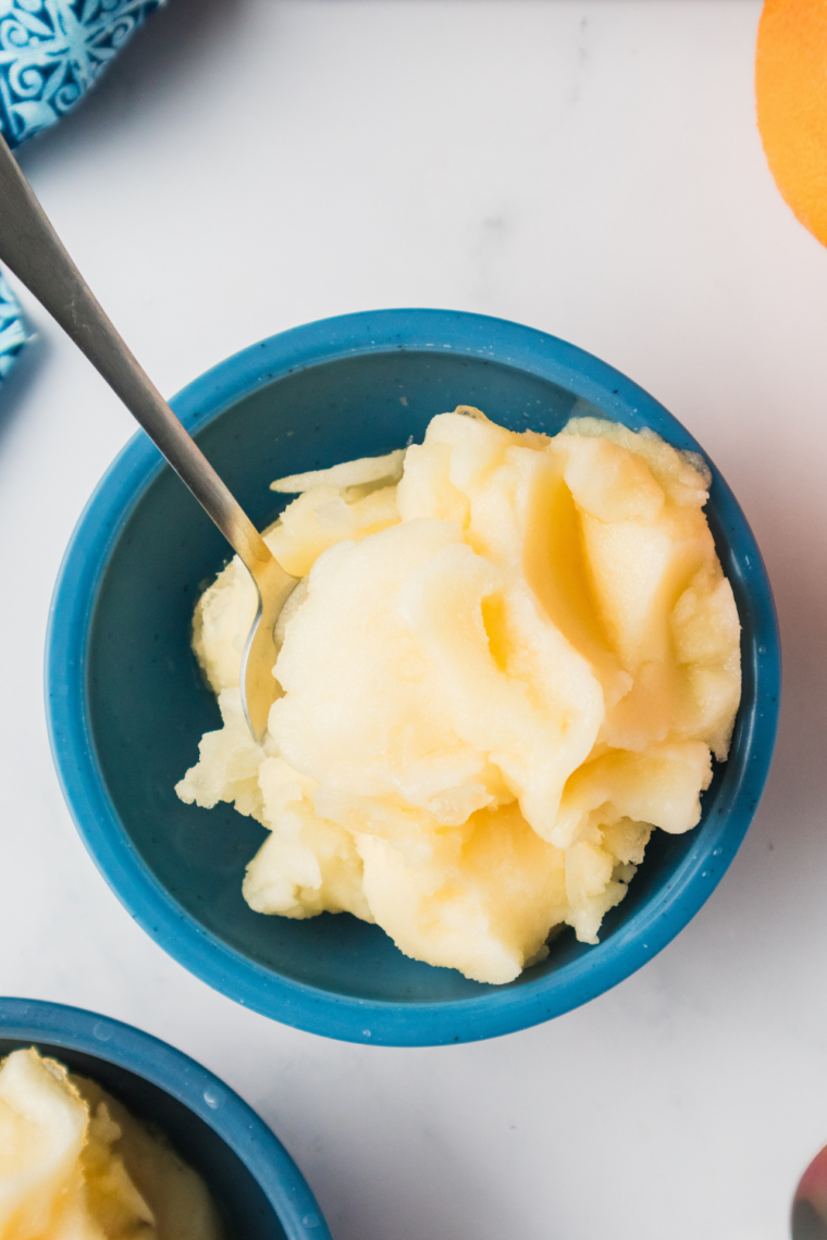 Scoop of creamy, homemade lemon gelato in a bowl, garnished with fresh lemon zest.