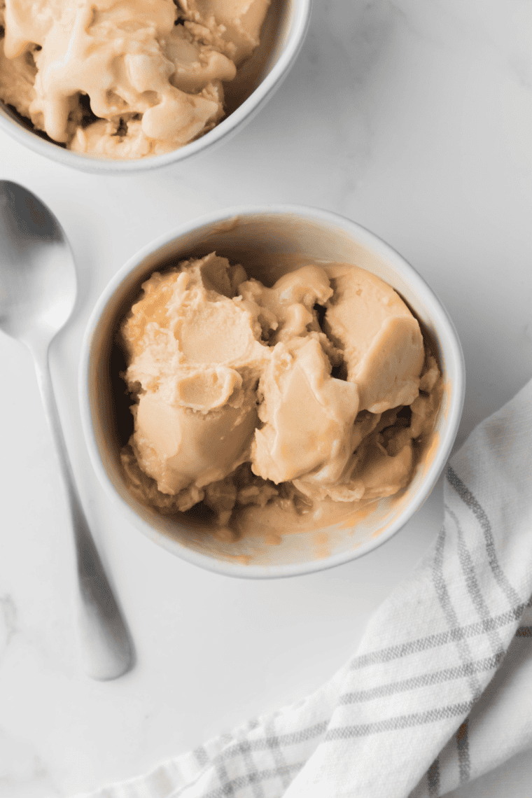 Glass of homemade Ninja Creami Starbucks Vanilla Frappuccino iced coffee topped with whipped cream.