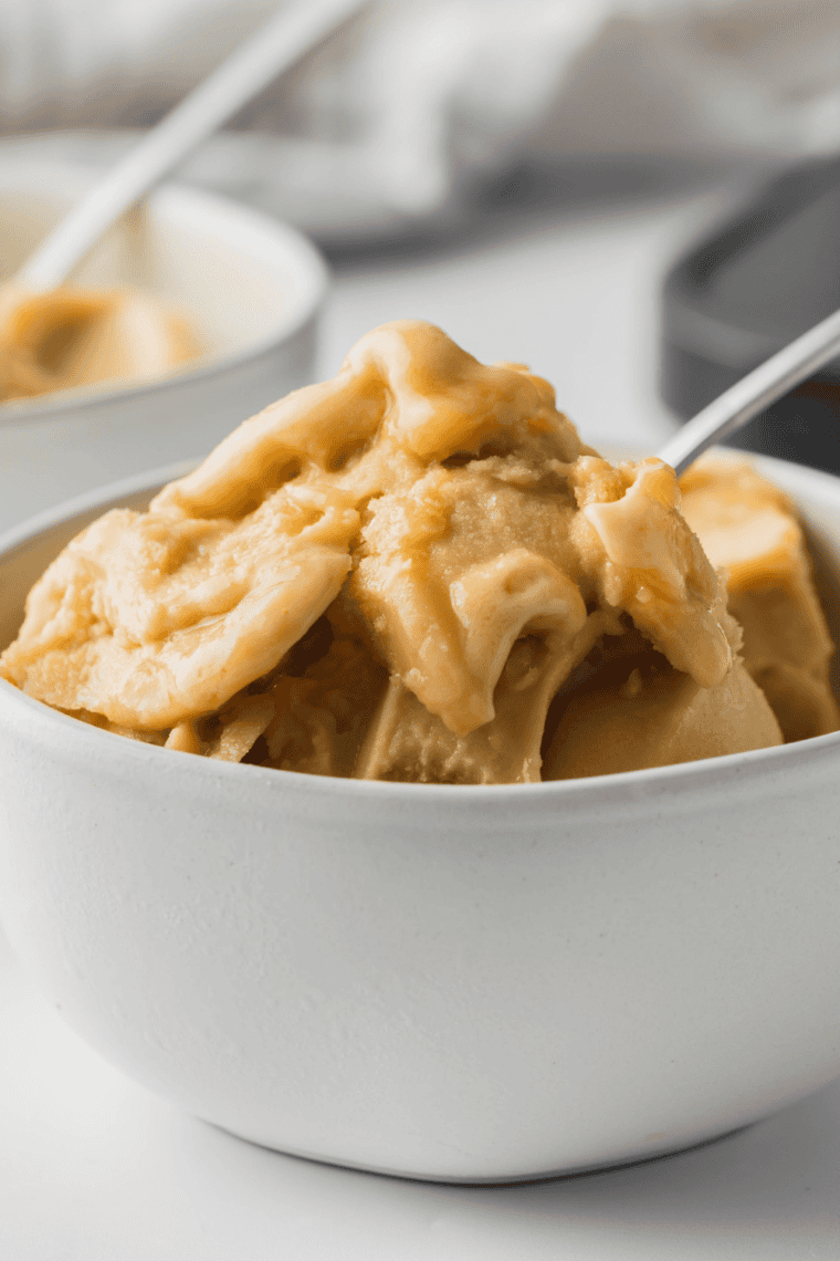 Glass of homemade Ninja Creami Starbucks Vanilla Frappuccino iced coffee topped with whipped cream, ready to serve.