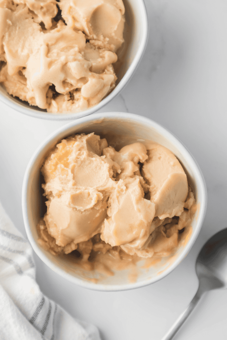 Homemade Ninja Creami Starbucks Vanilla Frappuccino iced coffee in a glass topped with whipped cream.