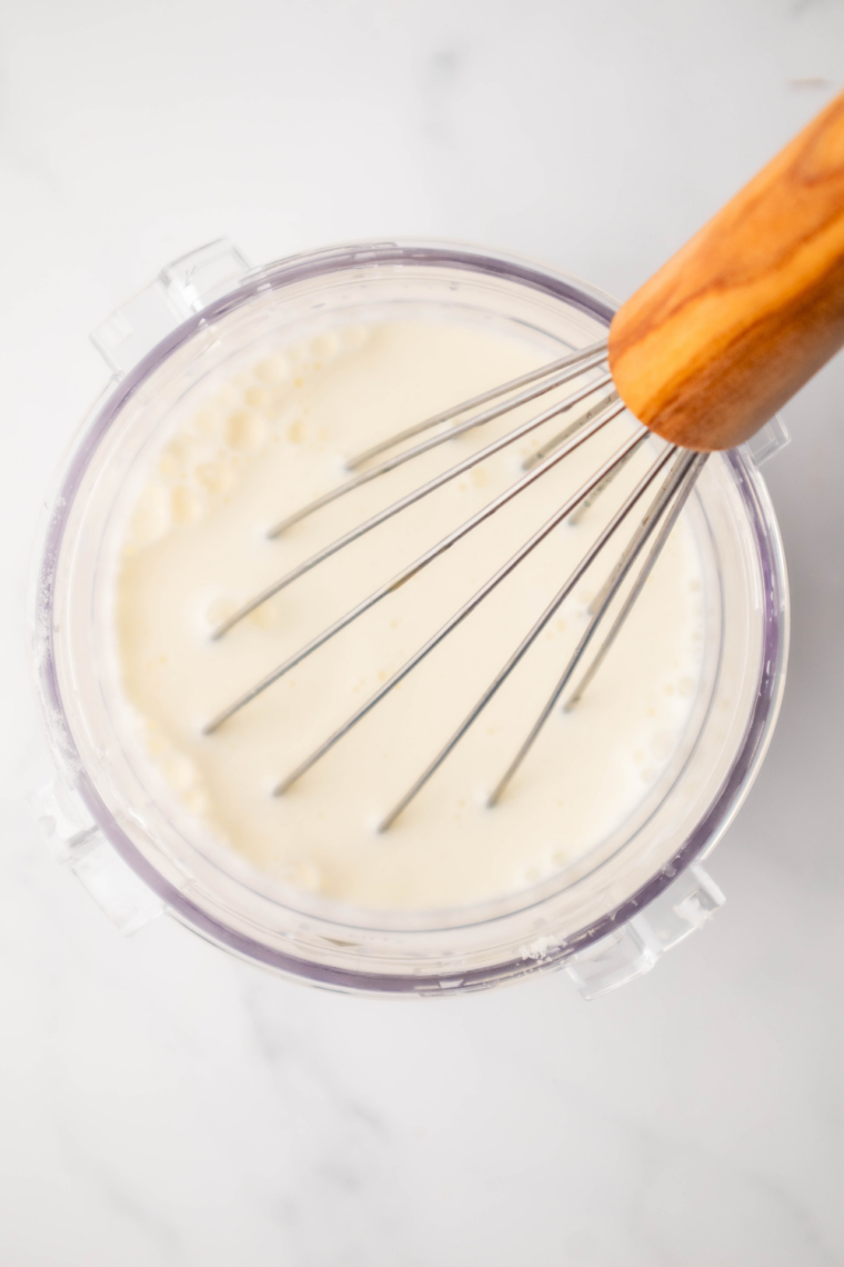 Milk, cream, sugar, and vanilla mix whisked together in a bowl until smooth.
