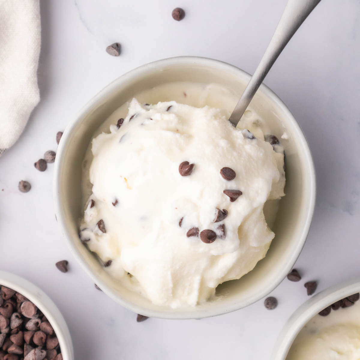 Creamy Ninja Creami stracciatella gelato in a bowl with chocolate flakes throughout.