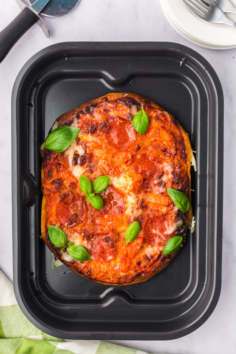 Freshly baked woodfire pizza sliced on a cutting board, ready to eat.