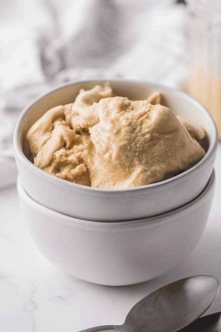 Homemade Ninja Creami White Chocolate Mocha Frappuccino in a glass topped with whipped cream and chocolate drizzle.